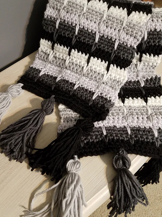 The Winter's Ice Tasselled Scarf Crochet Pattern shown in grey, black, and white