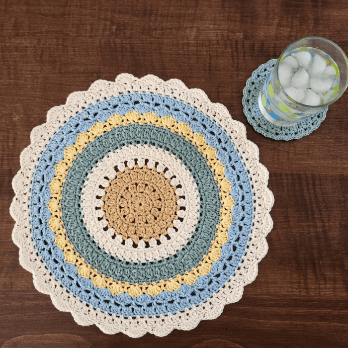 crochet placemat and coaster pattern set shown with a glass of water as a place setting